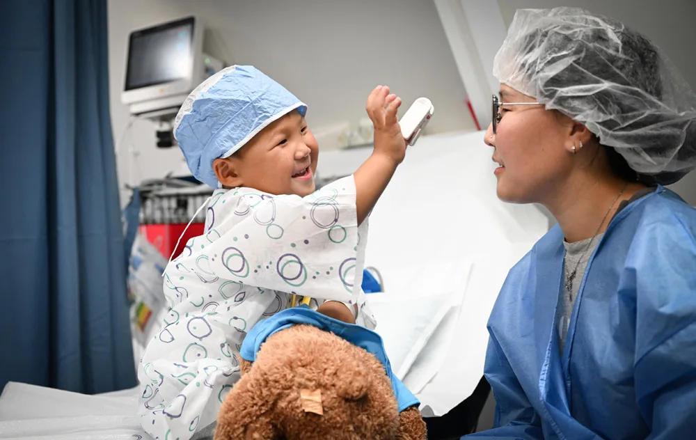Ulaanbaatar, Mongolia - Accompanied by his mother, Bayarkhuu (age 3), an oculoplastics patient is prepped for surgery on the Orbis Flying Eye Hospital.